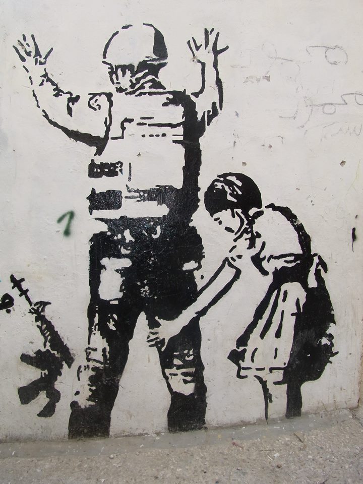 Murales di bambina che perquisisce soldato